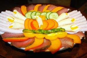 On a Plate of Sliced Pieces of Meat and Vegetables. Cucumbers, B photo