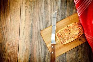 Sliced Bread with Sesame Seeds on a Wooden Board photo