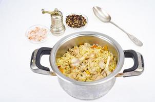 Pilaf with rice and meat in saucepan. photo