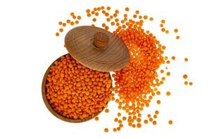 Red lentils in wooden jar on white background photo