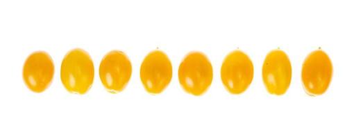 Oval yellow tomatoes on white background. Photo