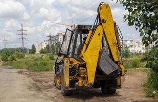 Excavator on a construction site against the background of the sky. Heavy machinery at work. A large yellow construction vehicle at a construction site. Industrial image. photo