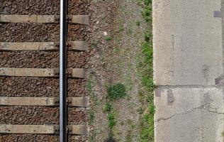 Railroad top view, flat lay. Part of the track for trains. Aerial view of a railway from a drone. Background with space for text. Shiny iron rails and concrete sleepers. photo