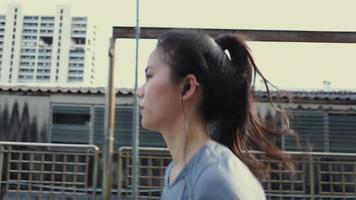 Woman athlete listening to music while running in the city. video