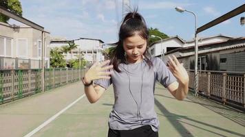 Woman stretching legs and warming before running while listening to music video