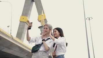mujeres asiáticas felices en un chat de video con amigos disfrutando de viajar en Tailandia.