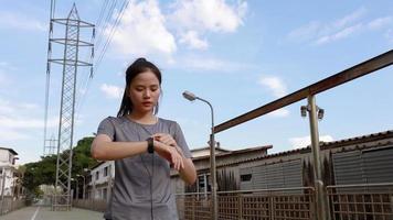 Asiatische Sportlerin, die die Herzfrequenz auf einer Smartwatch betrachtet. video