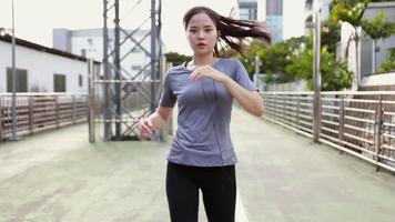 mujer joven atleta asiática descansando después de una carrera. video