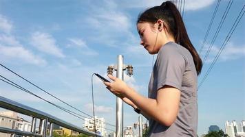 atleta femenina usando un teléfono inteligente después de correr. video