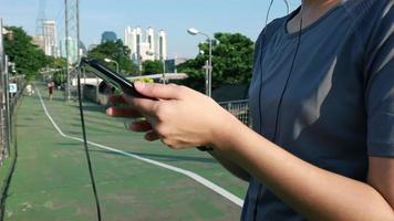 atleta femenina que usa un teléfono inteligente para verificar la frecuencia cardíaca después de correr. video