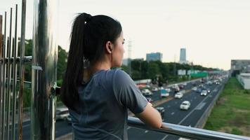Female athlete looking at traffic on the road after running