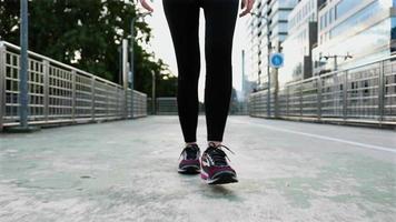 gambe asiatiche dell'atleta femminile che camminano sulla strada. video
