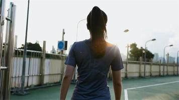 Atleta mujer asiática caminando por la calle después de una carrera. video