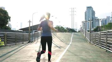 Atleta mujer asiática corriendo en la calle de la ciudad. video