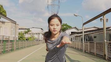 Woman stretching legs and warming before running while listening to music video