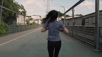 Young Asian woman athlete running in the city video