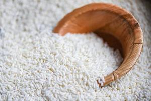 arroz blanco jazmín con cuenco de la naturaleza en el saco, cosecha de arroz y concepto de cocción de granos de alimentos foto