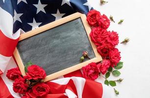 Red roses over the USA flag and black letter board top view flat lay photo