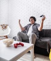 Excited young man playing video games at home enjoying his victory photo
