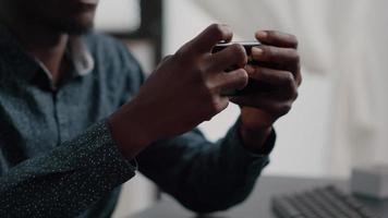 Close up of black man hands playing online internet mobile video games
