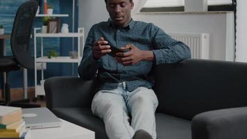 African american man playing video games on his phone