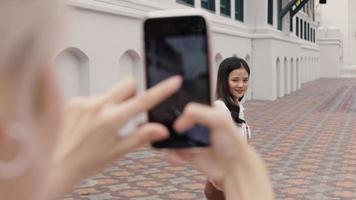 mujer asiática usando teléfonos inteligentes tomando una foto. video
