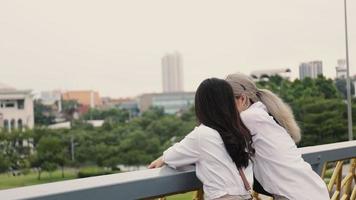 Asian woman enjoy traveling and talking while standing on the bridge. video