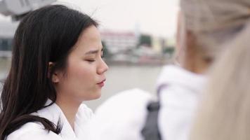 mujer asiática hablando mientras está de pie en el puente.