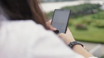 femme asiatique utilisant un smartphone en se tenant debout sur un pont video