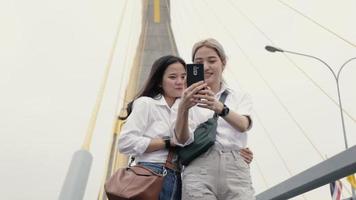 Happy Asian woman using smartphone selfies enjoying traveling in Thailand.