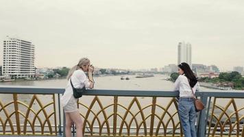 les femmes asiatiques aiment voyager en thaïlande et utiliser un appareil photo argentique pour prendre une photo. video