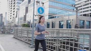 atleta mujer asiática corriendo en la ciudad.