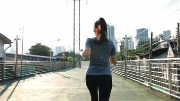 atleta asiatico che corre per strada in città. video