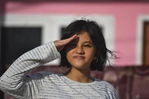una hermosa joven realizando un saludo militar. foto