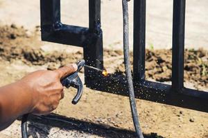 A worker is welding iron without wearing gloves. Light welding work. photo