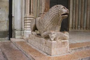Sculpture of lion with pray in front of Duomo in Modena, Italy photo