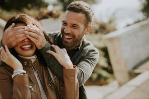 Young man covering the eyes of his girlfiend in the park photo