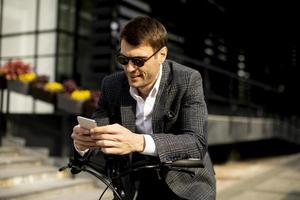 Young businessman on the ebike using mobile phone photo