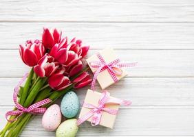 cajas de regalo, huevos de pascua y ramo de tulipanes foto