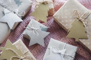 Christmas presents on pink knitted textile background. photo