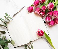 Pink spring tulips and notebook photo