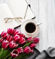 cuaderno, taza de café y tulipanes rosas foto