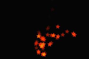 Efecto de luz estrella naranja claro textura de brillo de superposición aislada en negro. foto