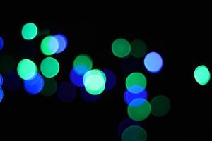 abstract green and blue urban realistic blurred glitter light colorful texture on black. photo