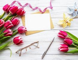 tulipanes de primavera rosa y tarjeta de felicitación foto