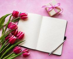 Notebook, gift box and pink tulips photo