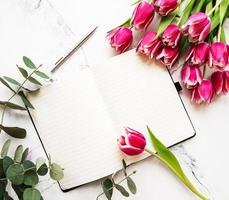 tulipanes de primavera rosa y cuaderno foto