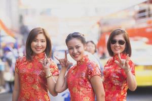 group of asian woman wearing chinese tradition clothes toothy smiling face happiness emotion and hand sign i love you photo