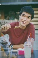 Asian man eating barbecue with happiness face photo