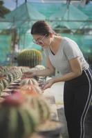 Mujer asiática cuidando de plantar macetas en el jardín de cactus